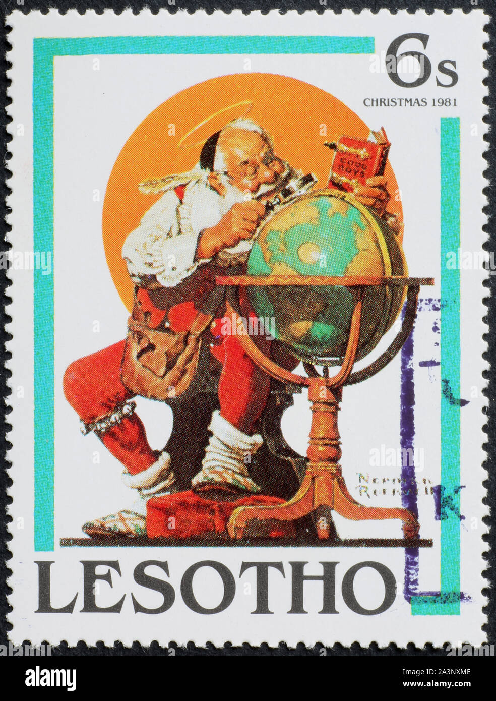 Santa Claus studying globe by Norman Rockwell on stamp Stock Photo