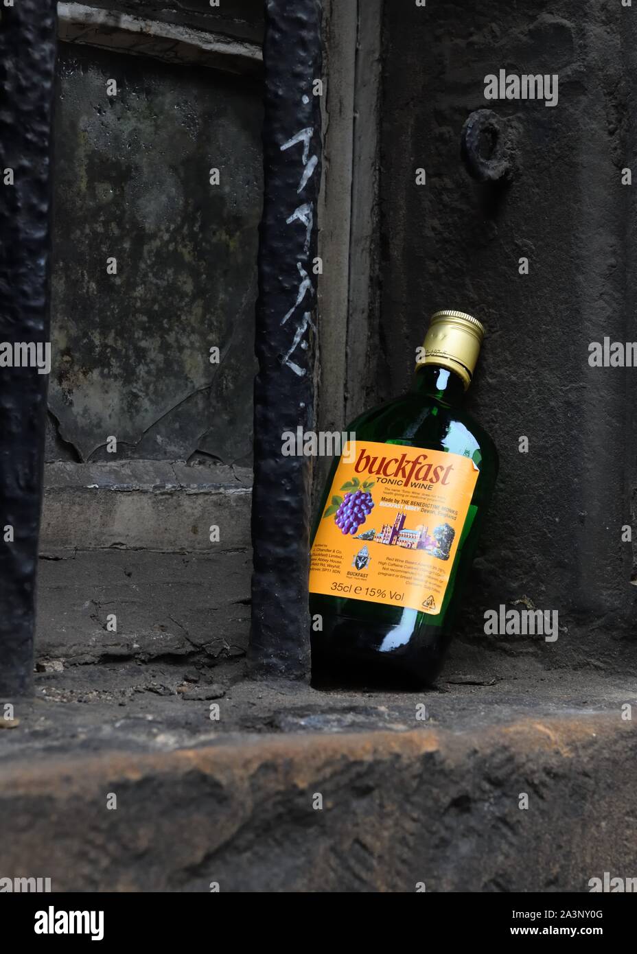 An empty half bottle of the cheap Buckfast wine propped up on an old dirty window ledge in Edinburgh, Scotland, UK, Europe Stock Photo