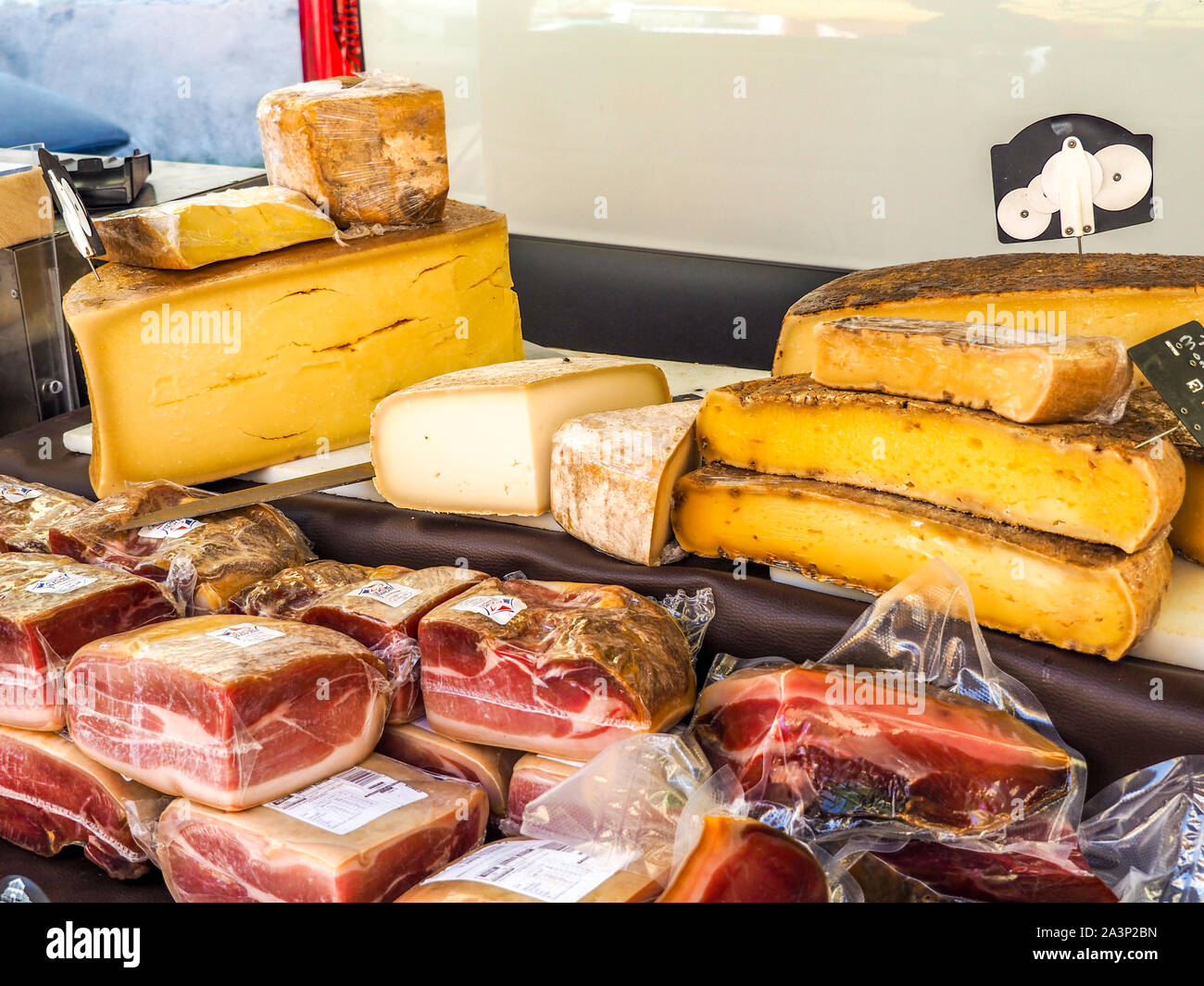 Meats and cheeses on sale at fresh produce market in Provence. Stock Photo