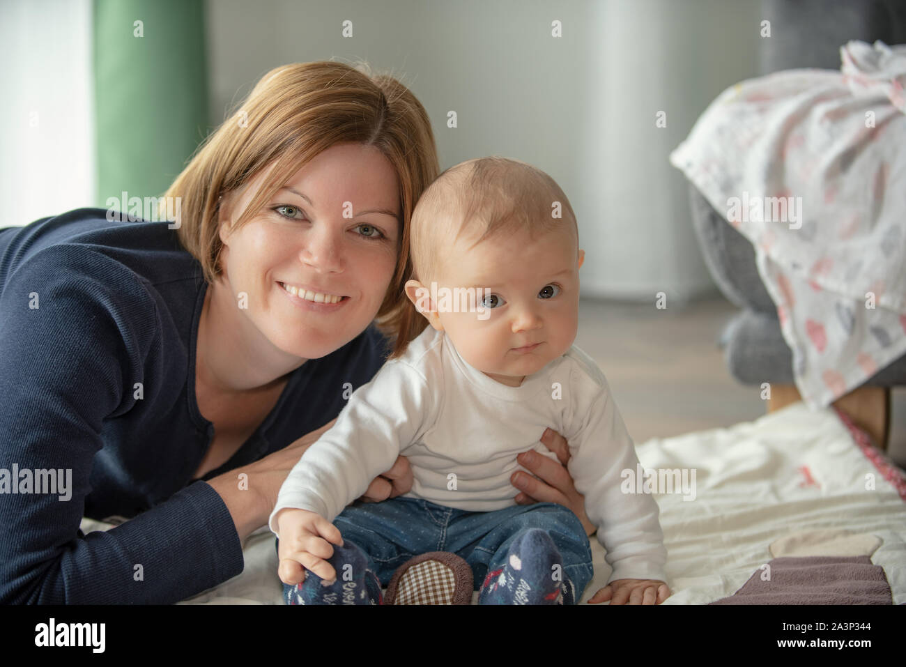 Happy mother holding her cute baby Stock Photo