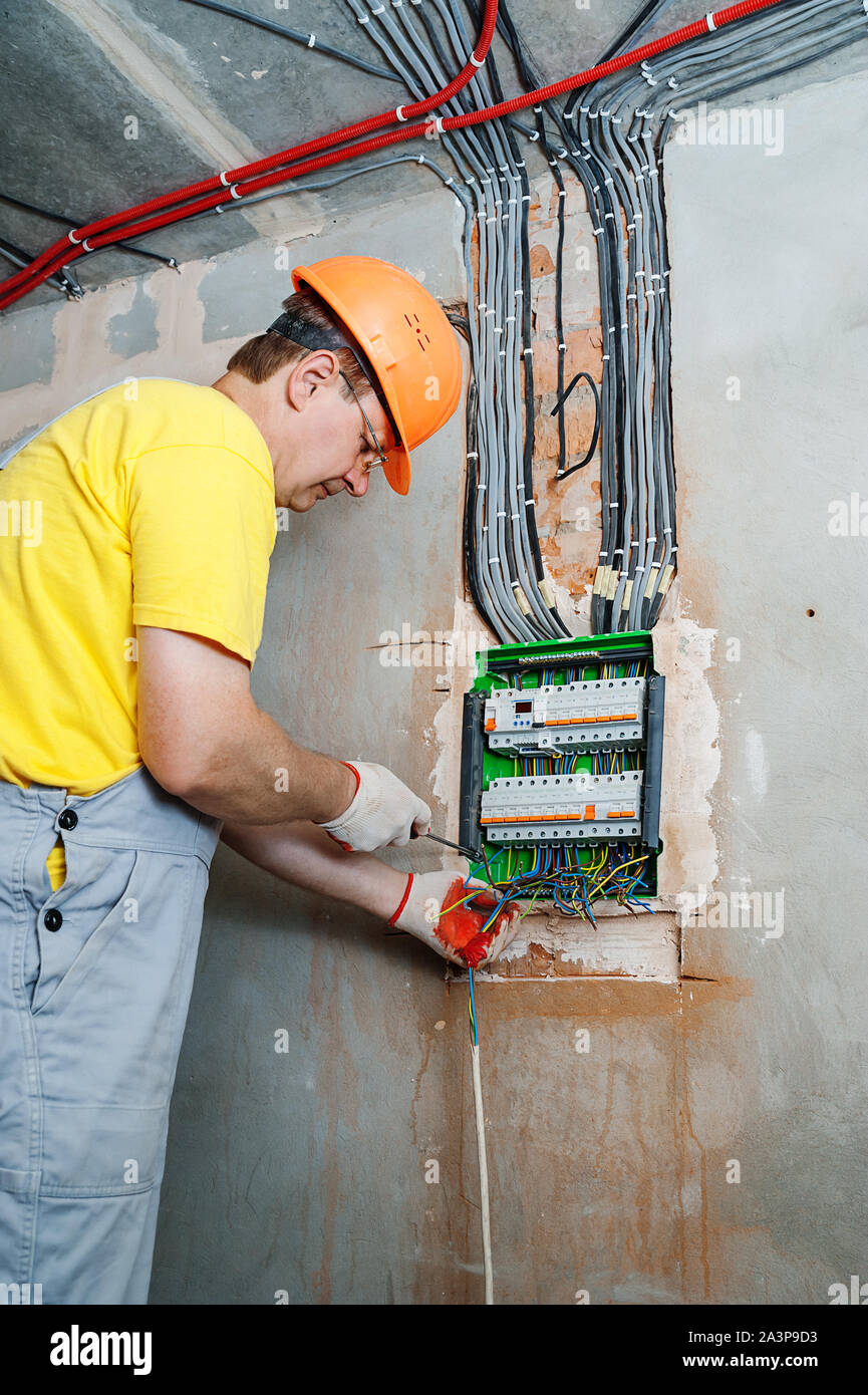 The electrician installing the fuses in the switch box. Stock Photo