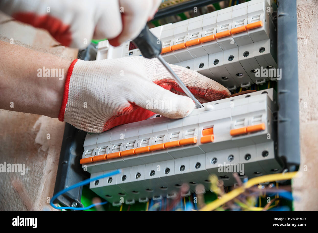 A electrician is installing the fuses in the switch box. Stock Photo