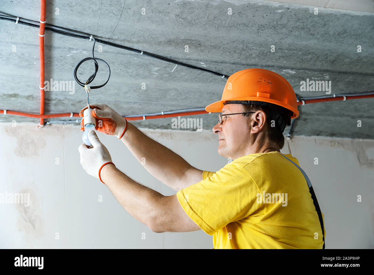 The electrician is setting a light bulb for temporary lighting Stock