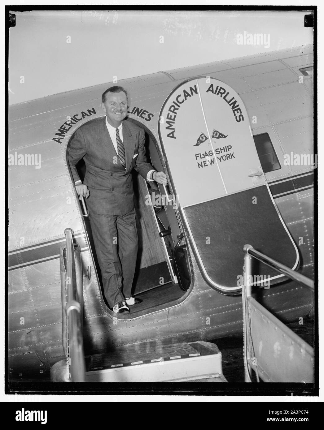 Song-bird pauses at Washington airport. Washington, D.C., July 11. Enroute from California, Lawrence Tibbett, song-bird star of 'The Circle,' well known radio program, stepped out of the flag ship of the American Airlines to take a breath of Washington Air before going on to New York. From there he will continue to Wilton, Conn., for a well earned vacation Stock Photo