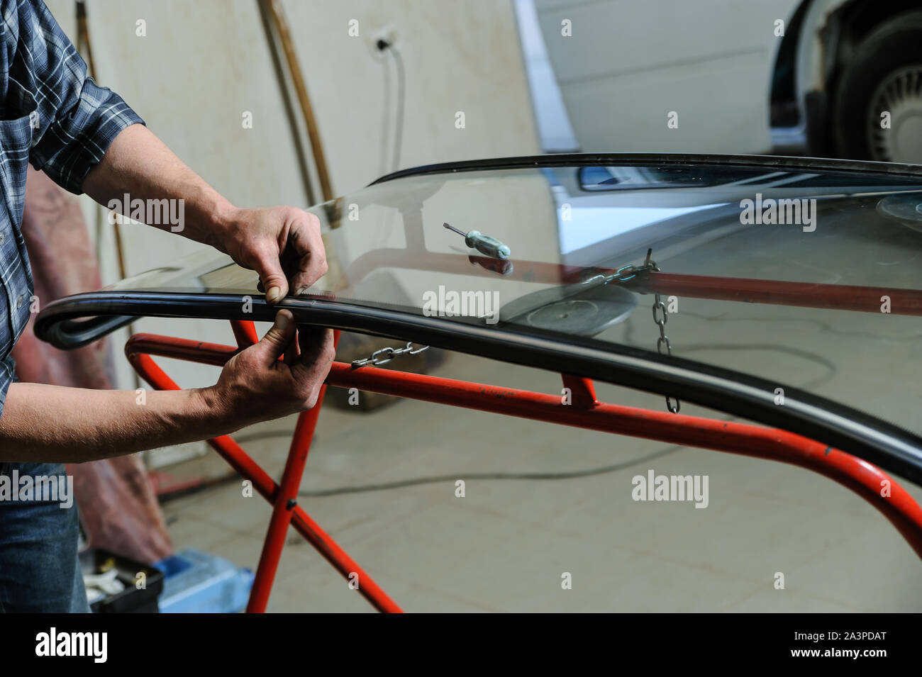 Car mechanic's hands are instilling decorative molding to seal of a