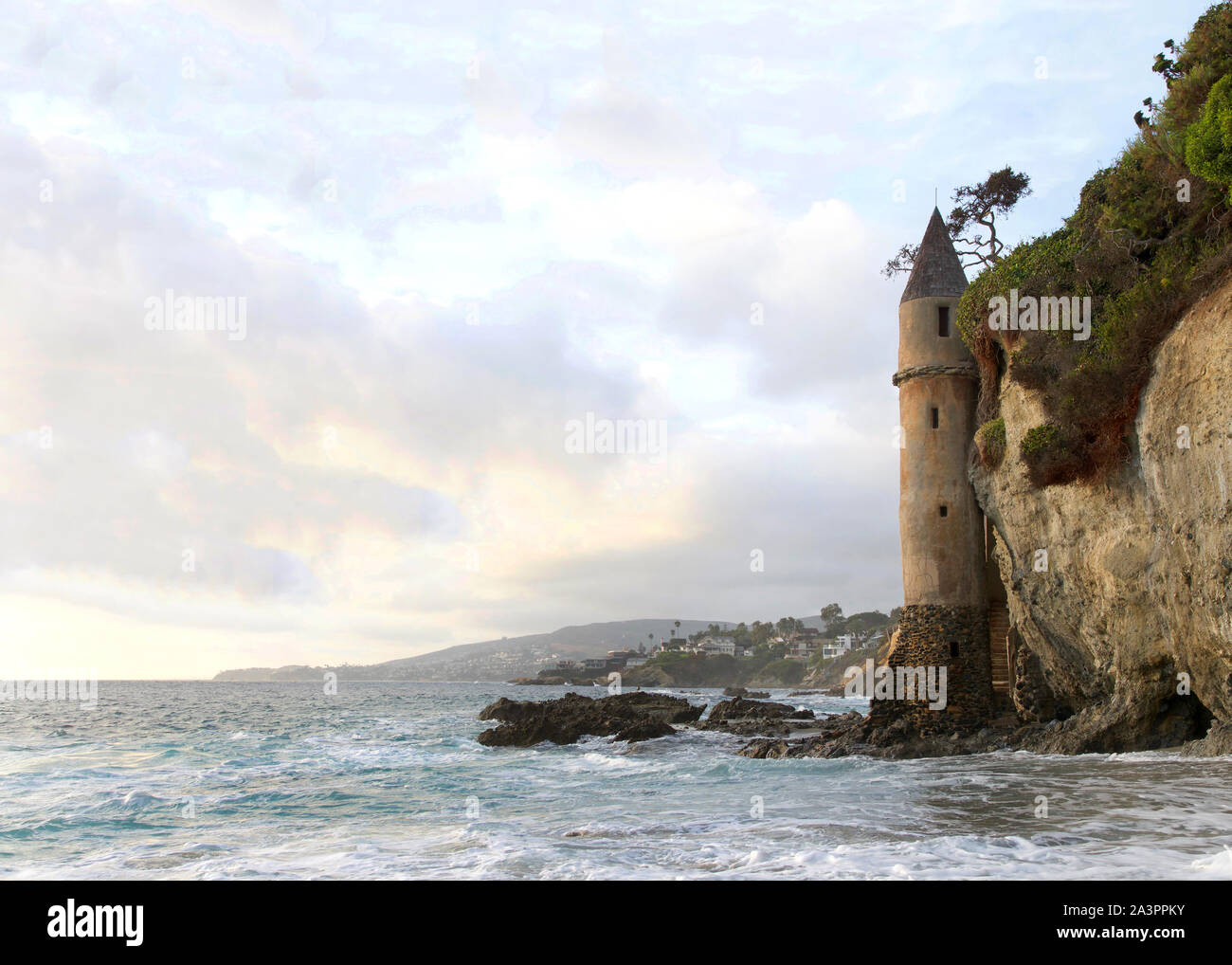 waves crashing on the rocks at the base of La Tour (the Tower) in Laguna Beach, California on a cloudy afternoon. One of the most unique and mysteriou Stock Photo