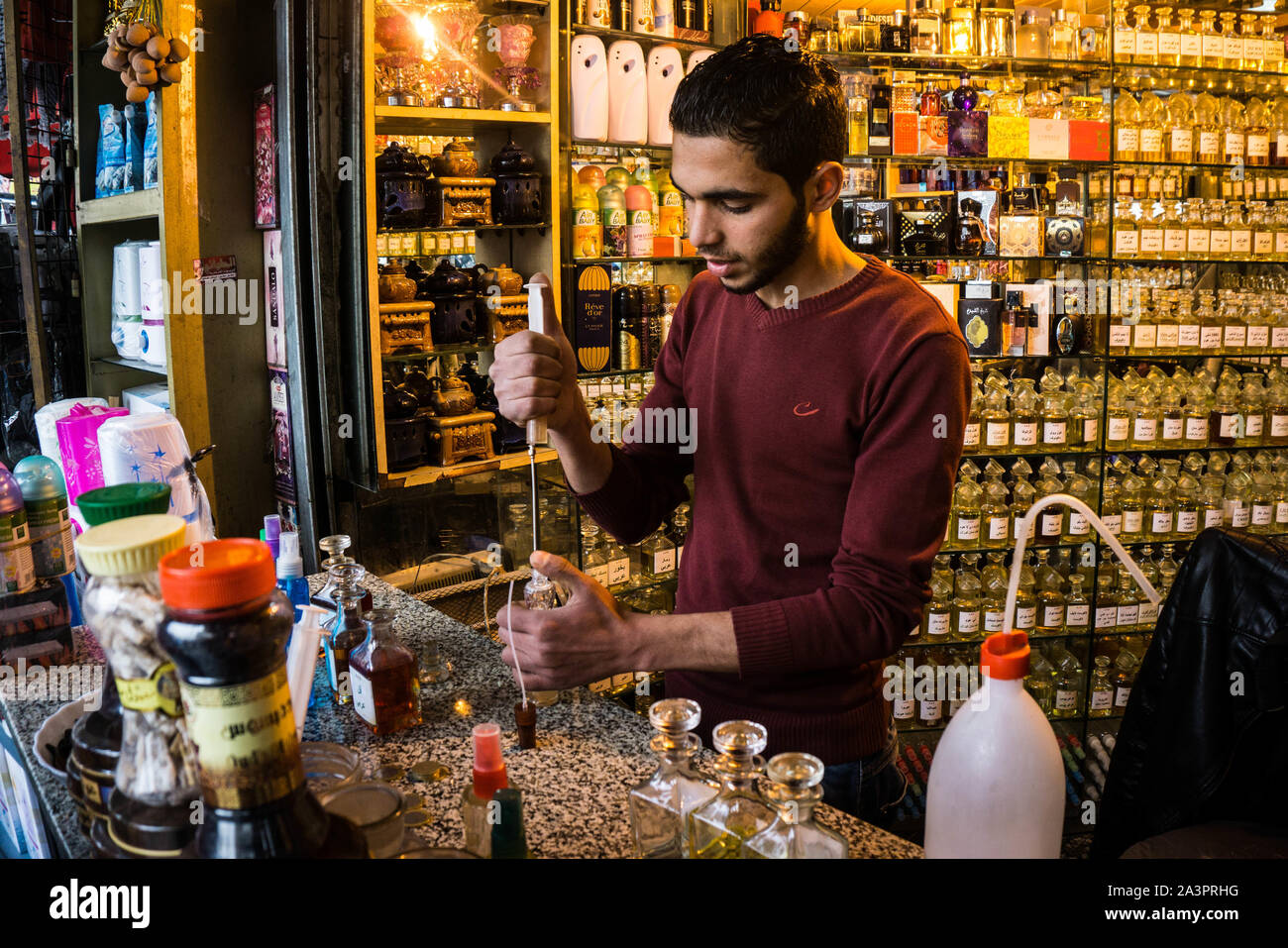 A local perfumer prepares perfume at a traditional Middle Eastern fragrance shop in downtown Amman, Jordan Stock Photo