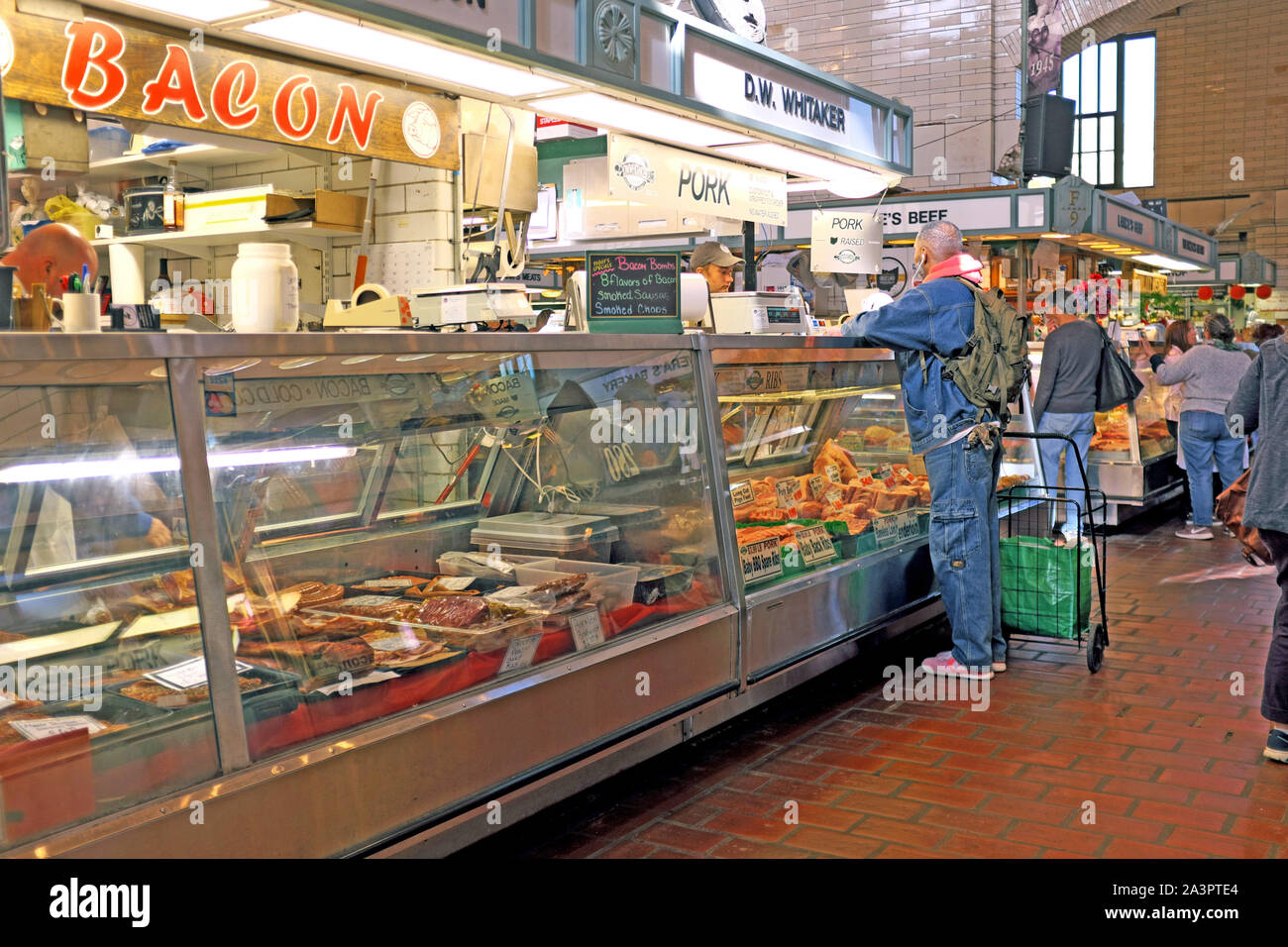 A customer purchases meat at D.W. Whitaker market stand inside the