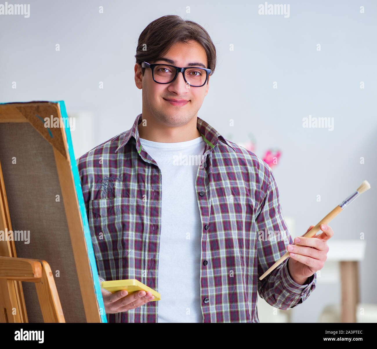 The young male artist drawing pictures in bright studio Stock Photo - Alamy
