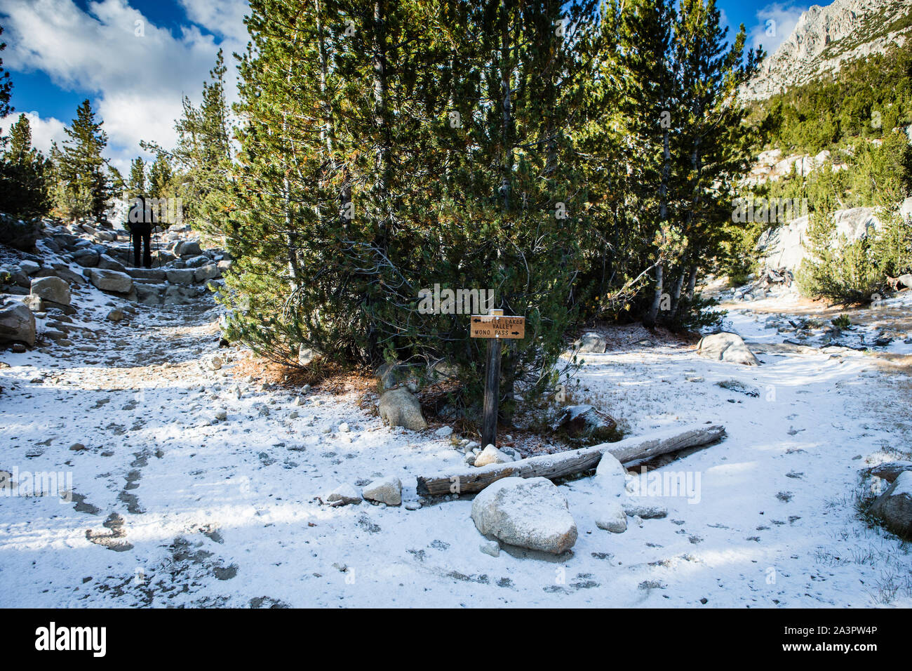 woman hiking in the snow covered trail along Little Lakes Valley in the Eastern Sierra Nevada Mountains. California USA Stock Photo