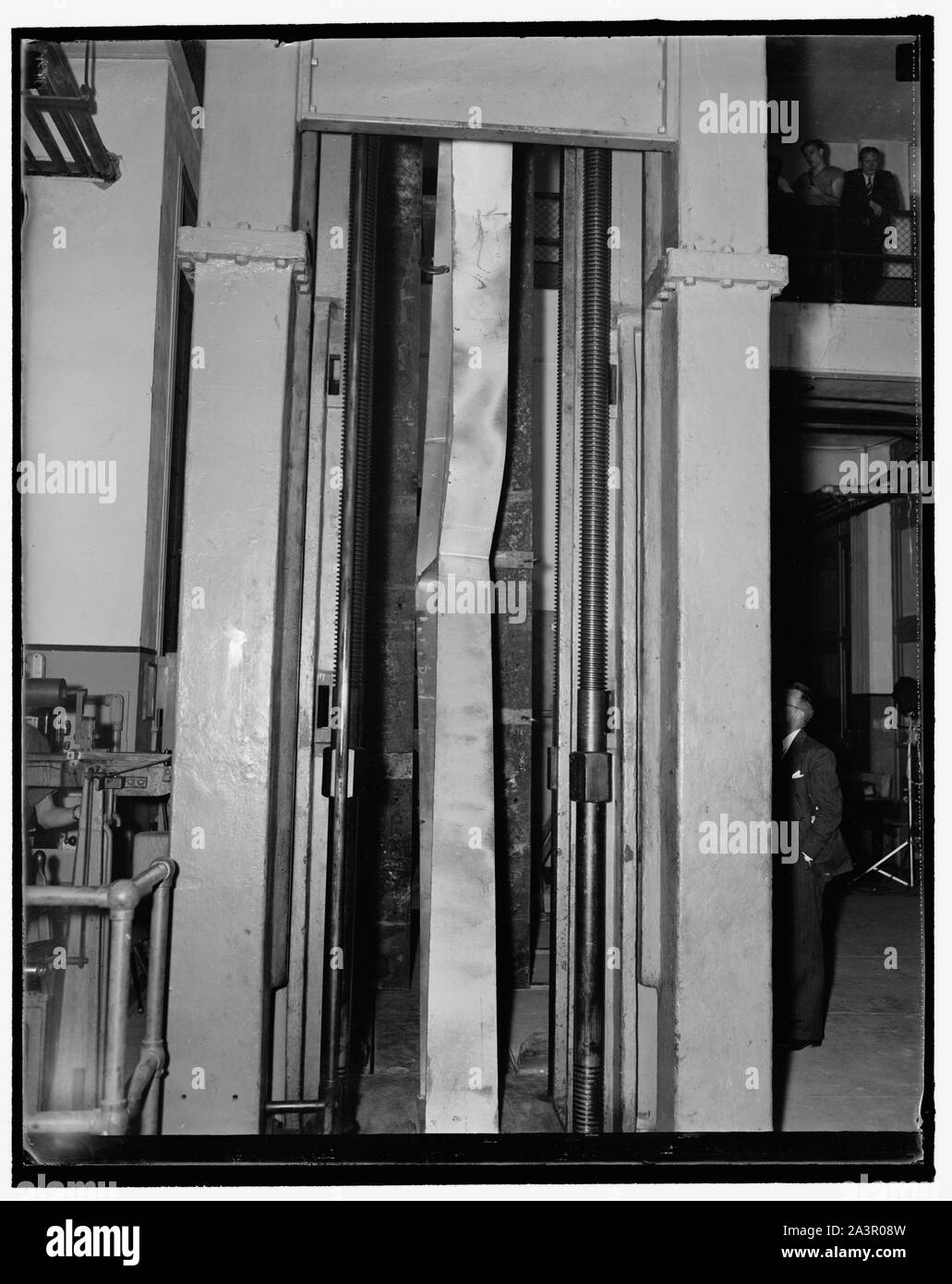 Steel bending. Washington, D.C., Sept. 23. English: Steel bending. Washington, D.C., Sept. 23. Photo shows the welded steel knees in the 600,000 lb. testing machine at the U.S. Bureau of Standards today, as it buckled under 153,600 lb. maximum load. This rigid steel frame knee was designed to withstand 60,000 lbs. 9/23/37 Stock Photo