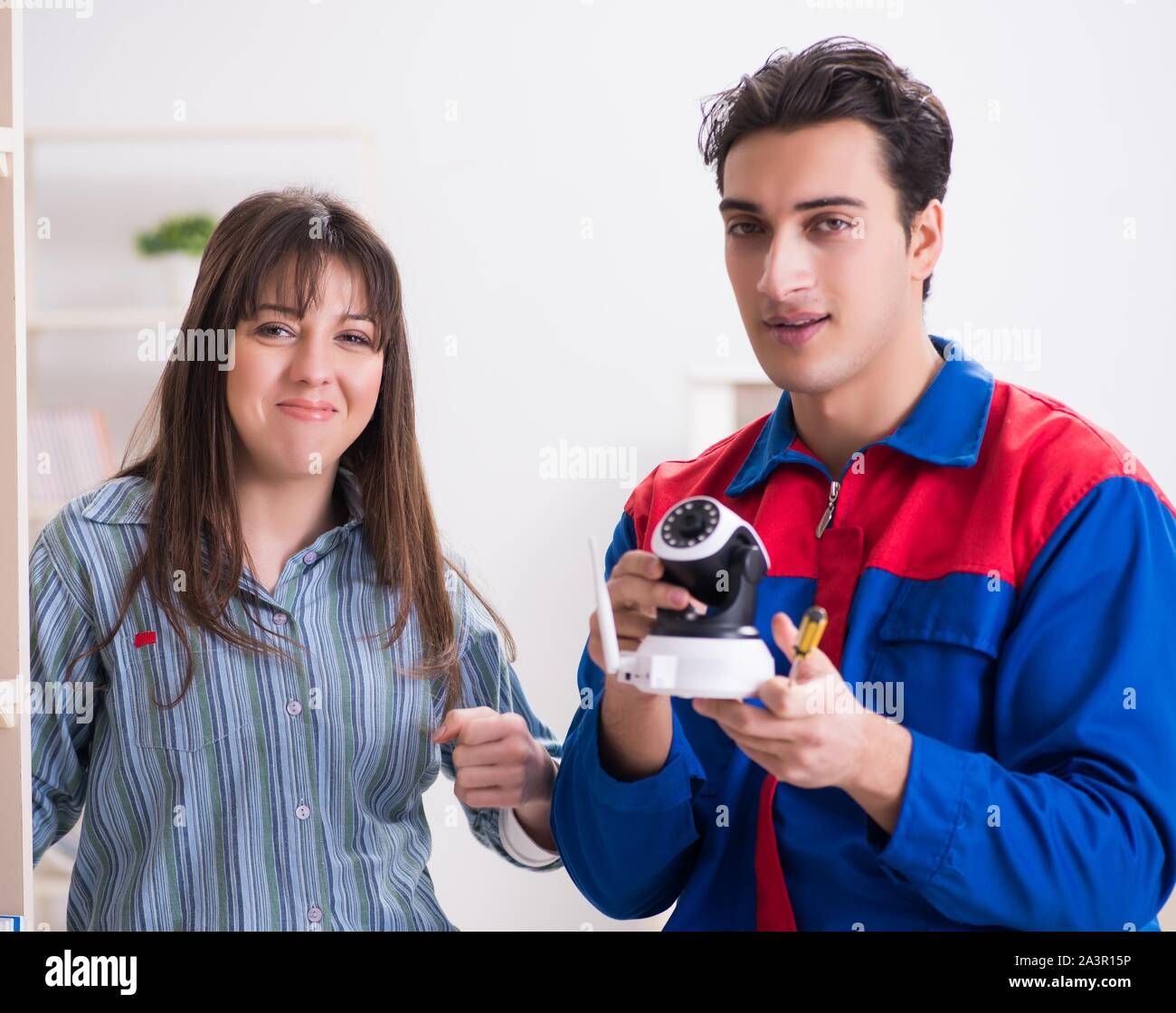 The client getting securty camera installed at home by contractor Stock Photo