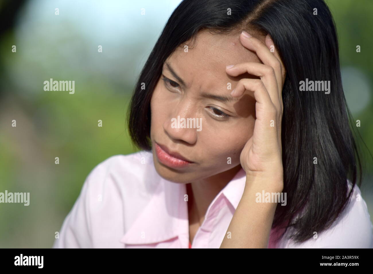 An Anxious Youthful Filipina Woman Stock Photo