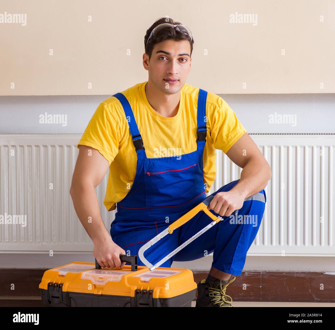 Young repairman contractor repairing heating panel Stock Photo