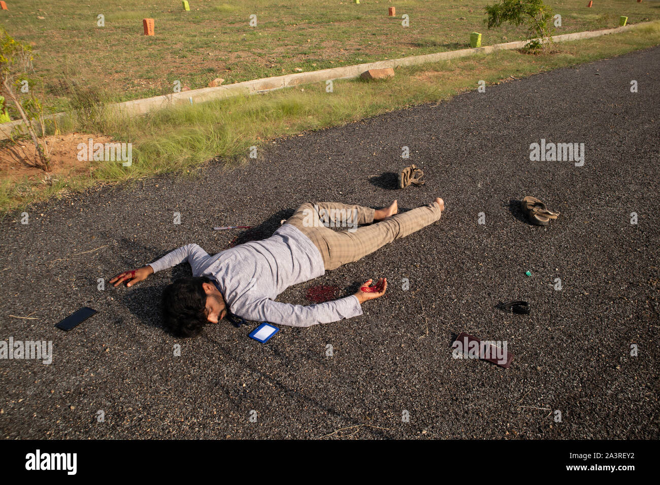 Concept of Crime scene, Wide angle shot of victim dead body laying on Road. Stock Photo
