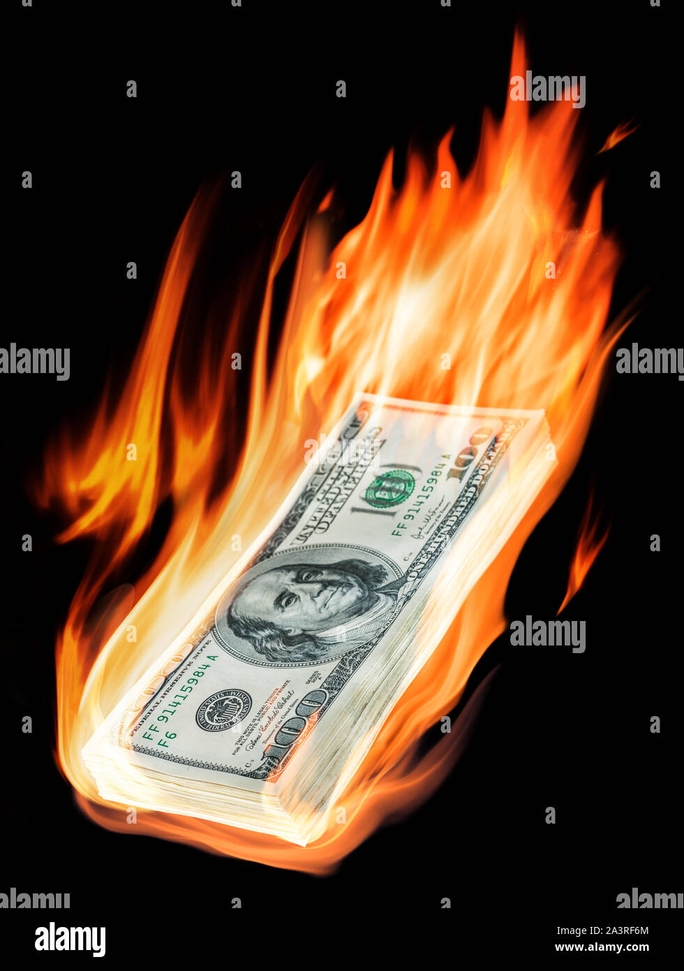 Burning one-hundred dollar bills in flames on black background. Conceptual picture. Stock Photo