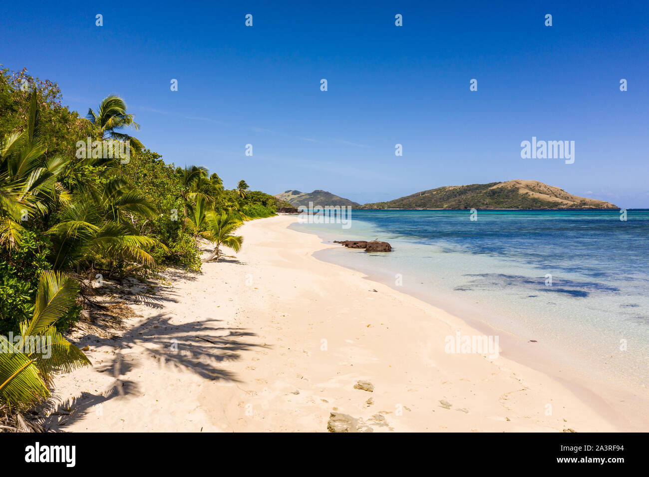 Stunning white sand beach by the blue lagoon in the Yasawa island in Fiji in the south Pacific. Stock Photo