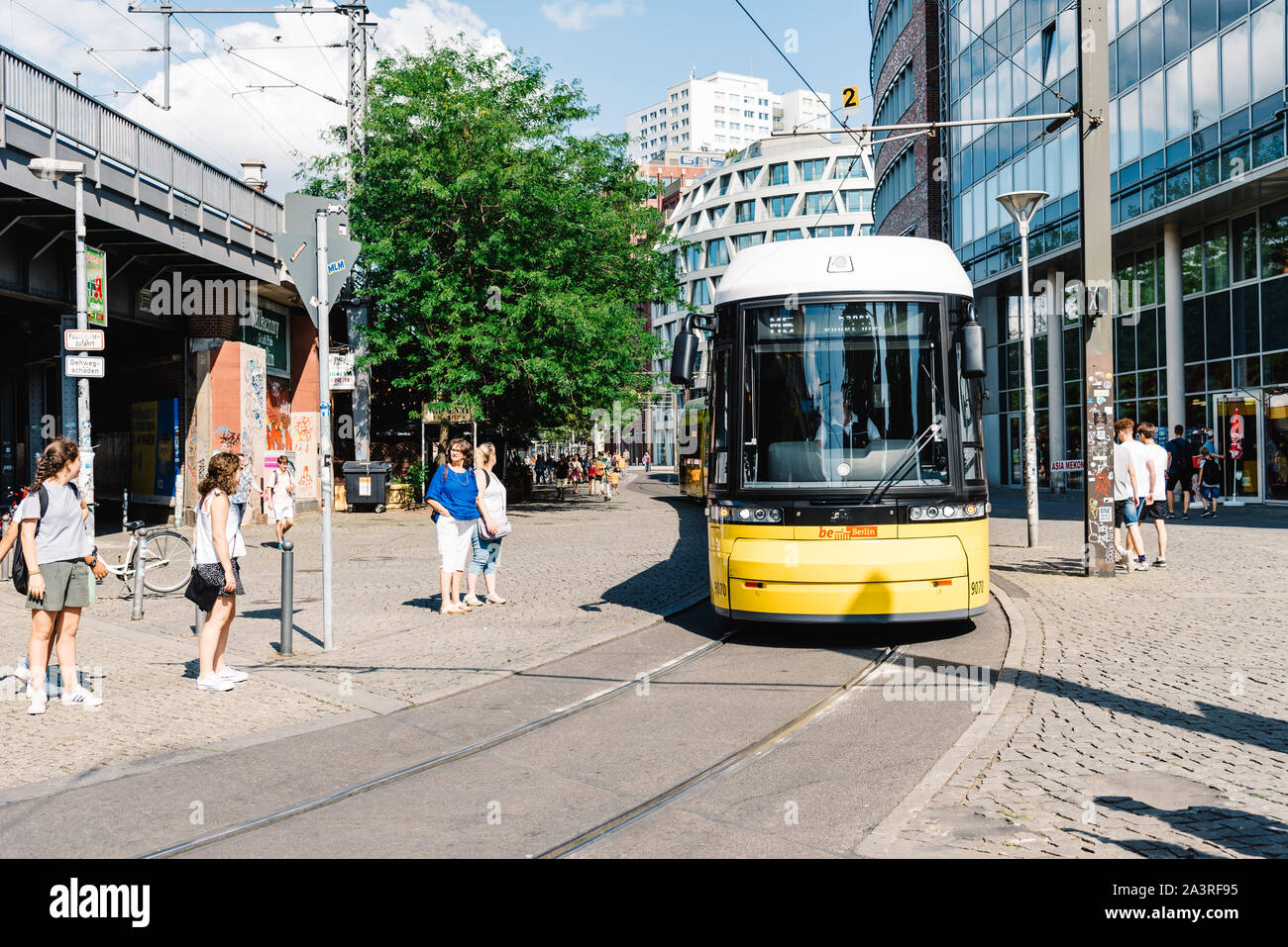 Berlin, Germany - July 27, 2019: Yellow public transportation tram passing by the city of Berlin. Sustainability concept Stock Photo
