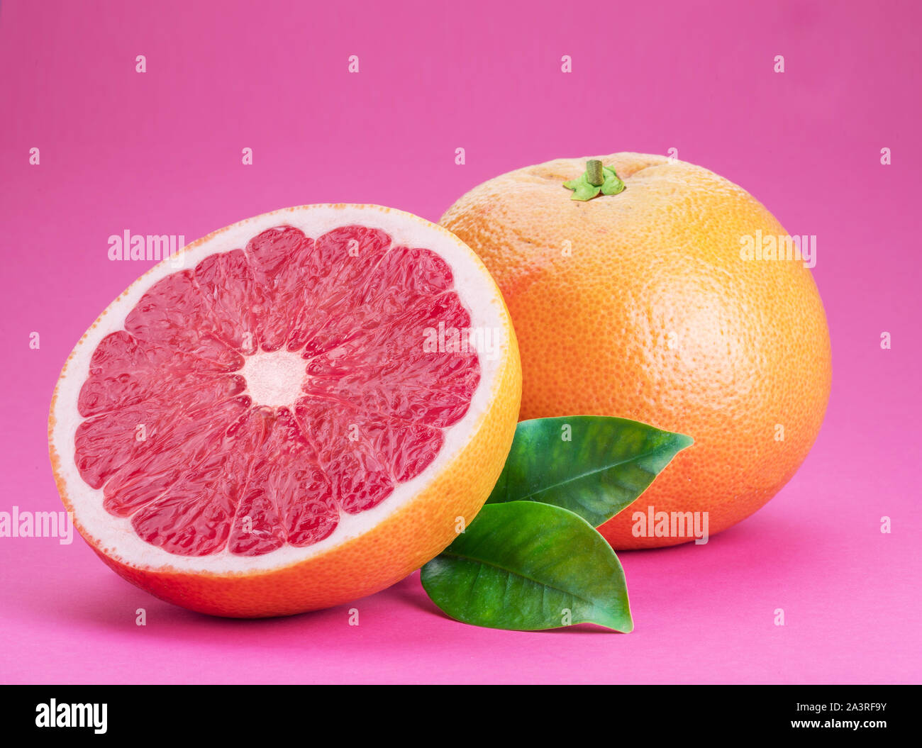 Grapefruit and grapefruit slice isolated on pink background. Stock Photo