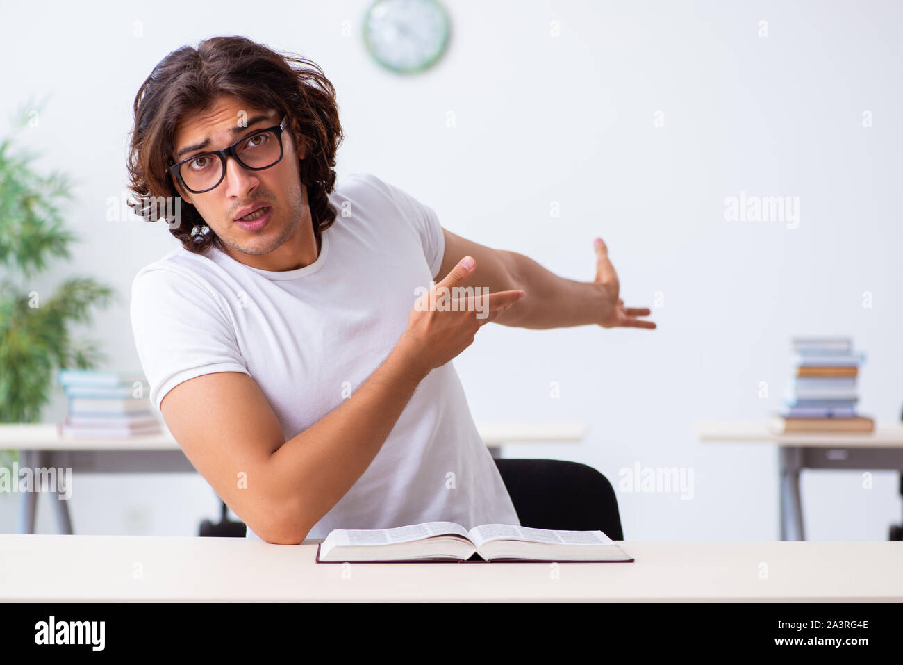 The young male student sitting in the classroom Stock Photo - Alamy