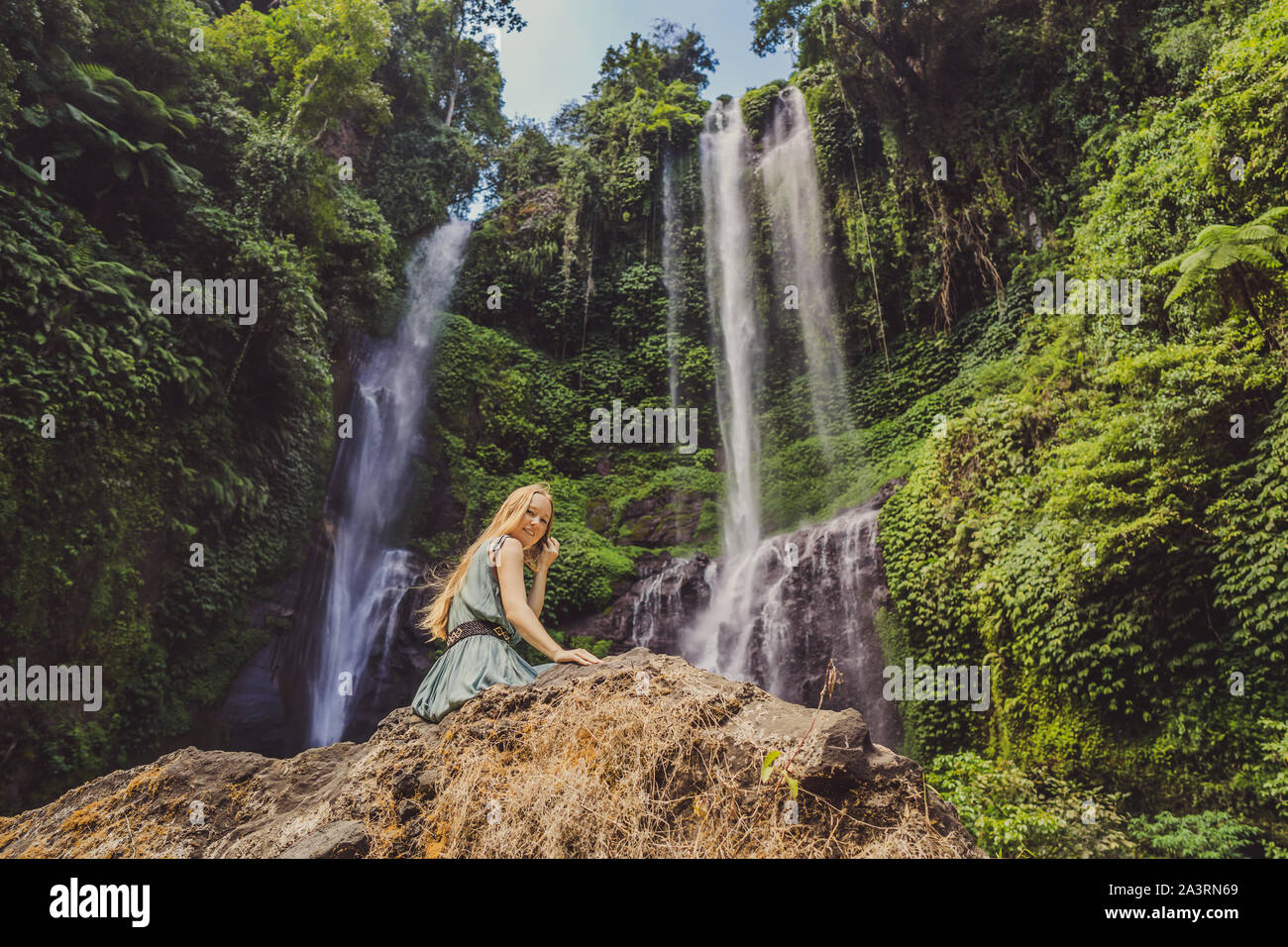 Woman in turquoise dress at the Sekumpul waterfalls in jungles on Bali ...