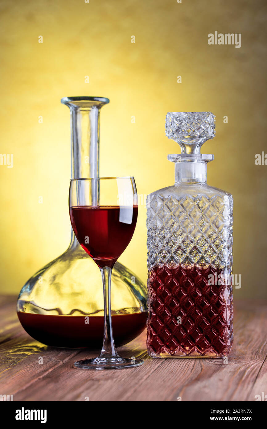 Decanters with red wine and glass on stucco background wiht clipping path. Stock Photo