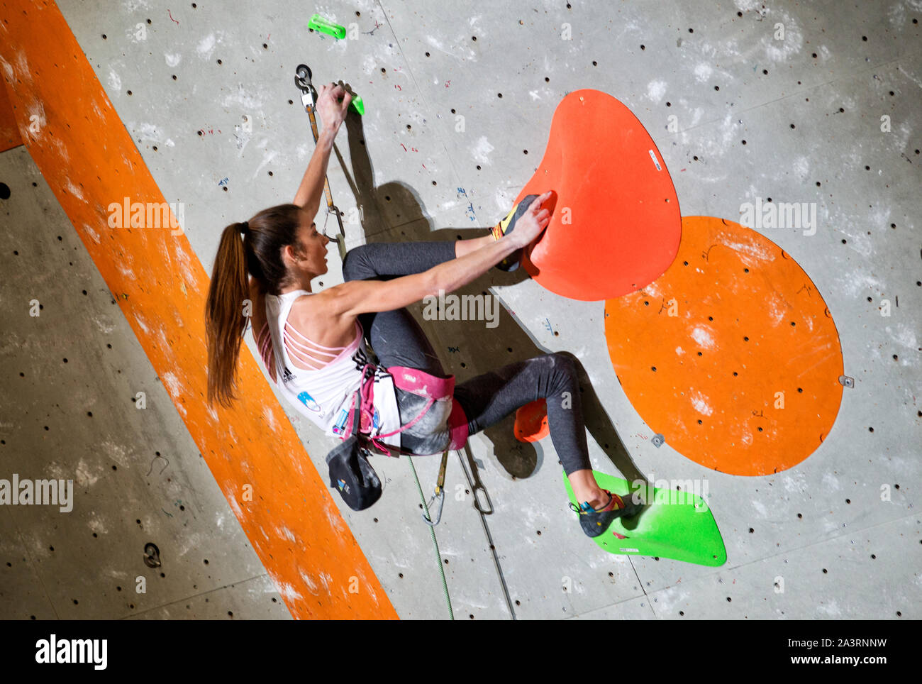 Young female climber in the lead on the climbing wall hires stock