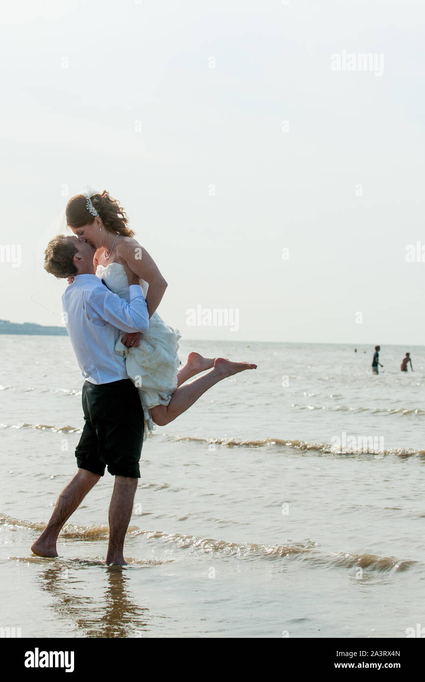 Bride and groom kiss in the sea Stock Photo - Alamy