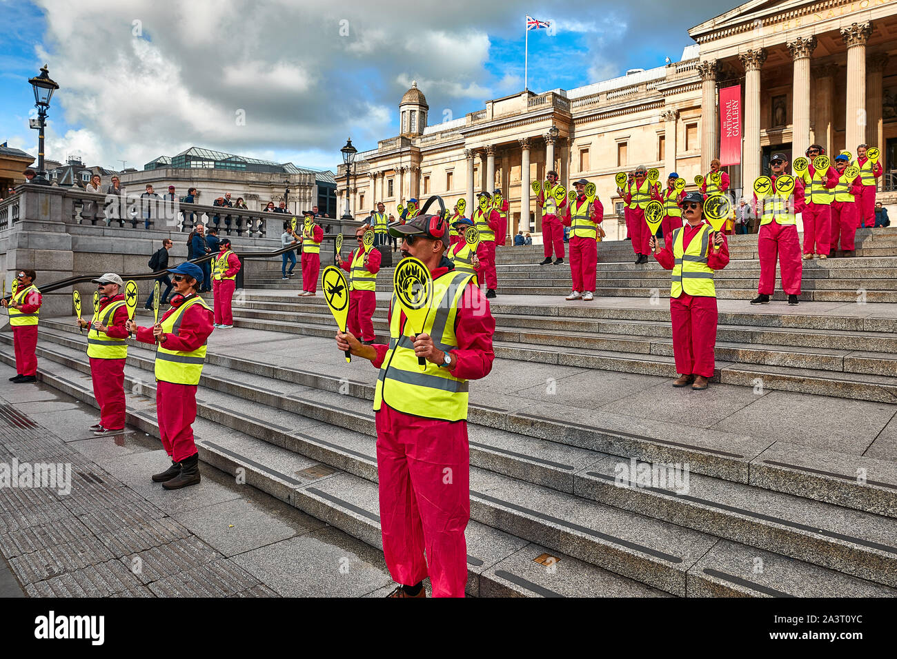 London, U.K. - Oct 9, 2019: Environmental campaigners from Extinction Rebellion dressed as airport landing workers in Trafalgar Square to protest against air travel. Stock Photo