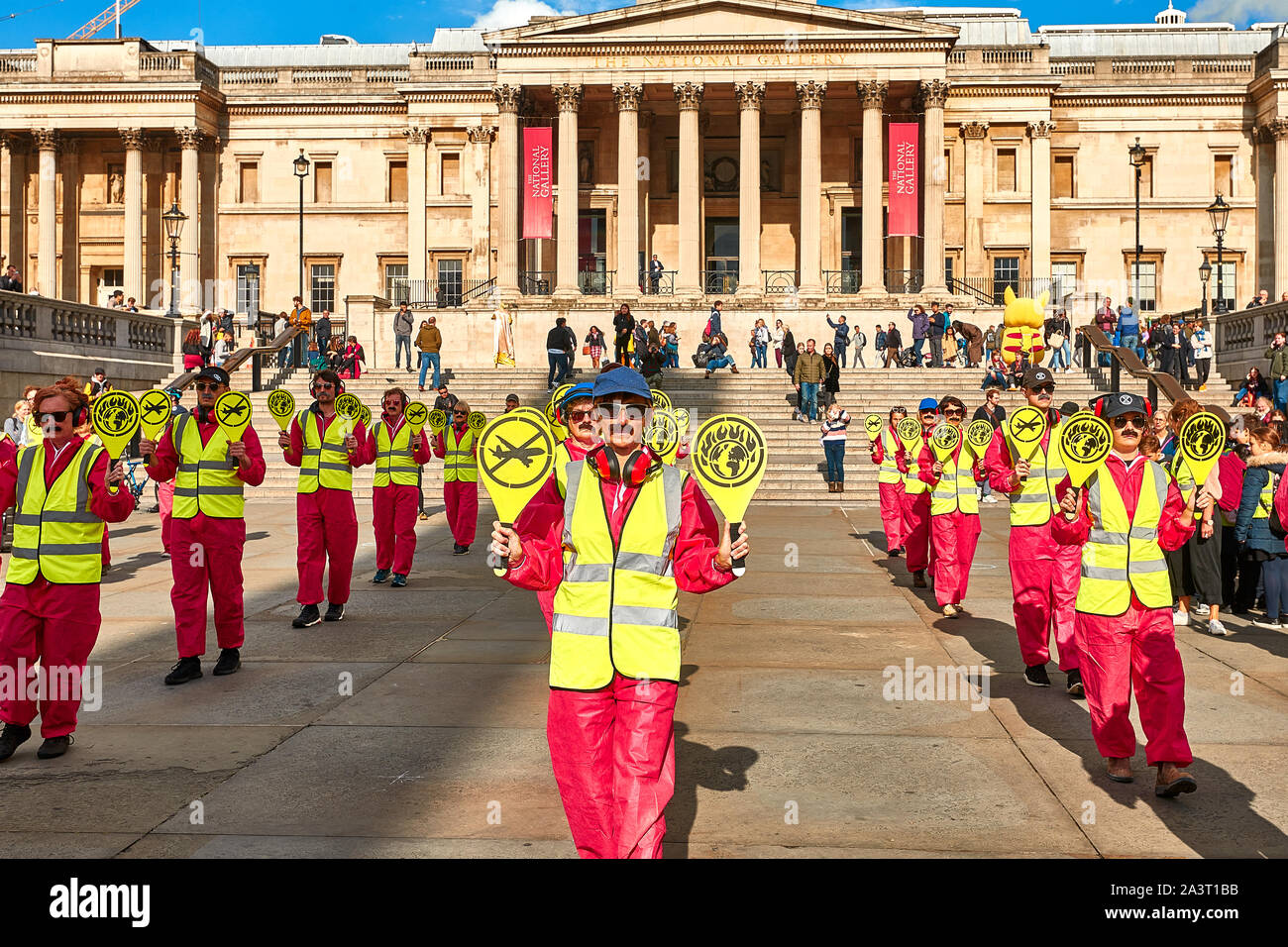 London, U.K. - Oct 9, 2019: Environmental campaigners from Extinction Rebellion dressed as airport landing workers in Trafalgar Square to protest against air travel. Stock Photo