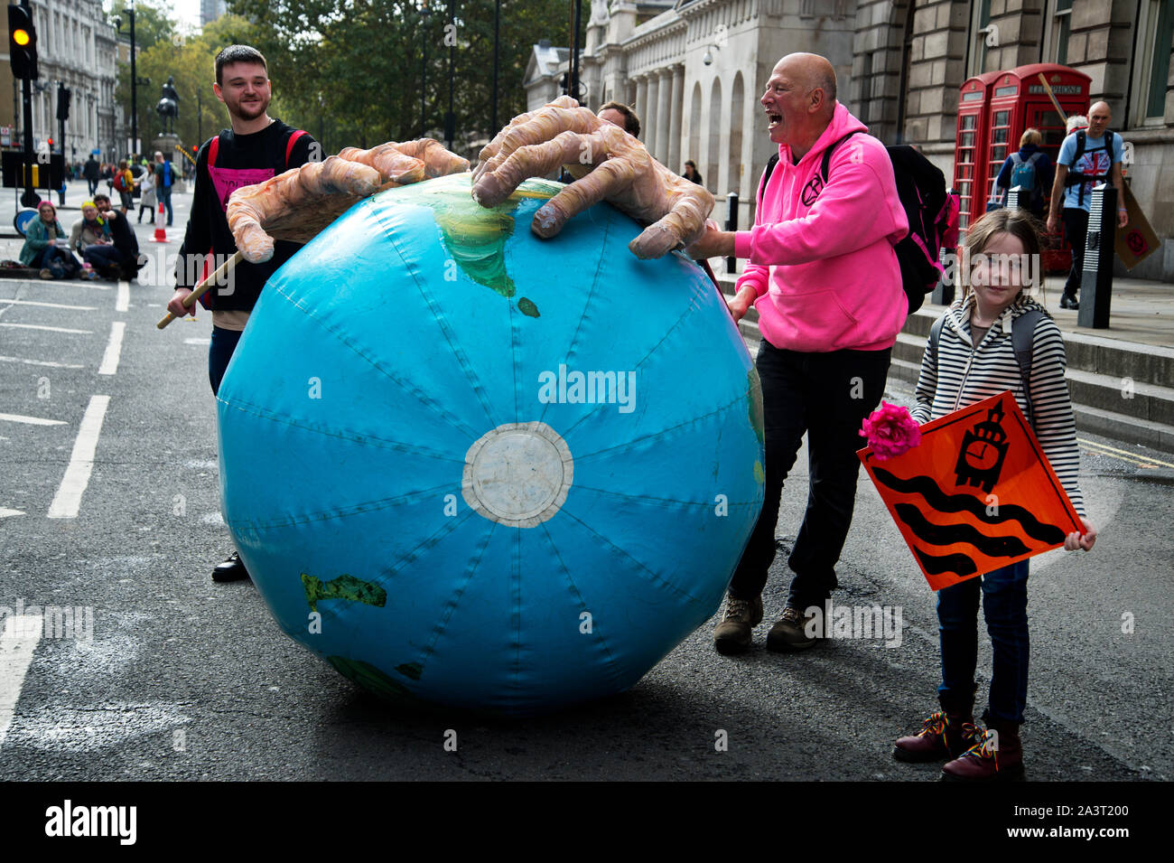 Extinction Rebellion, Central London, October 8th 2019 Greedy hands roll a mock planet earth down Whitehall Stock Photo