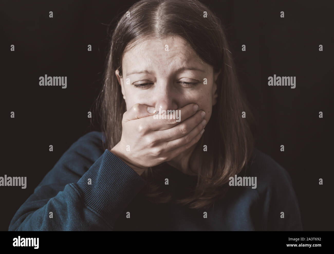 Violence. Crying woman on a black background. Stock Photo