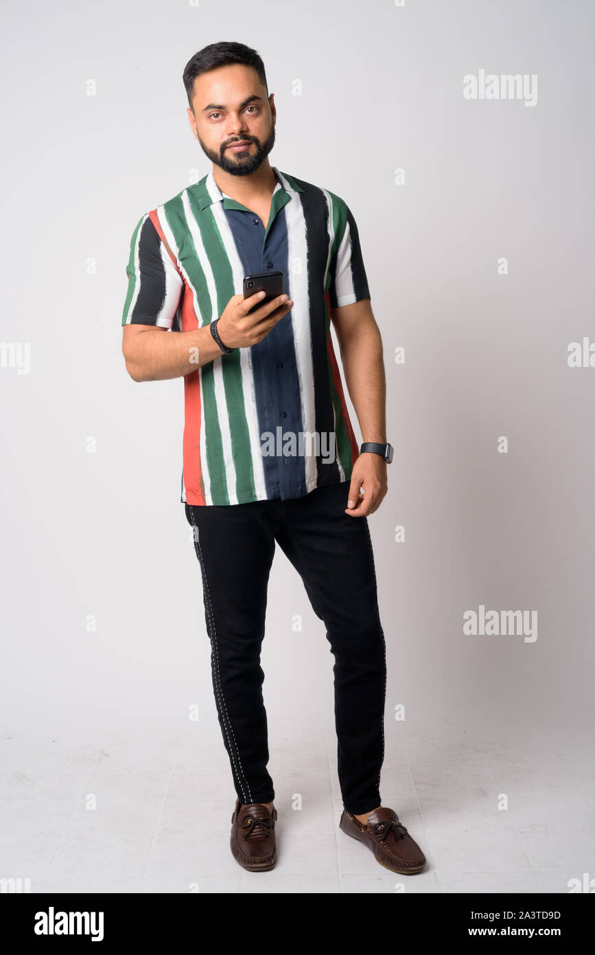 Full body shot of young bearded Indian man using phone Stock Photo - Alamy