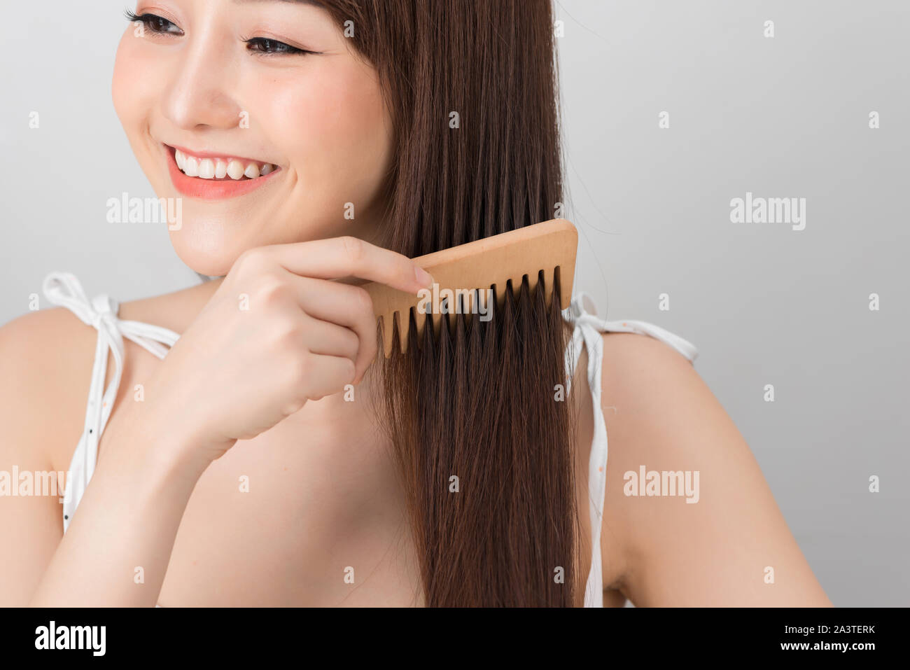 Asian woman combing her hair with a brush Stock Photo