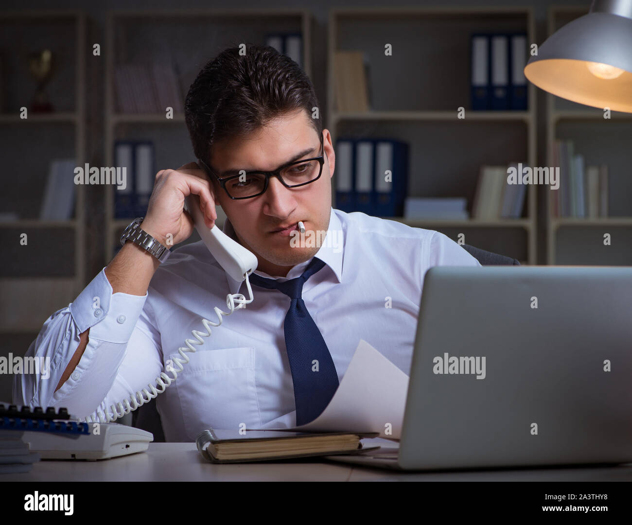 The businessman speaking on phone and smoking in office Stock Photo