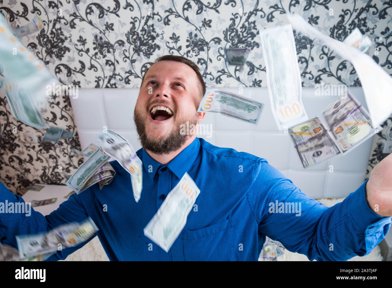 male enjoys tremendous wealth. man throws up a lot of banknotes on a