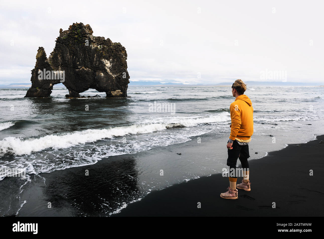 Tourist looks at the Hvitserkur basalt stack in northern Iceland Stock Photo