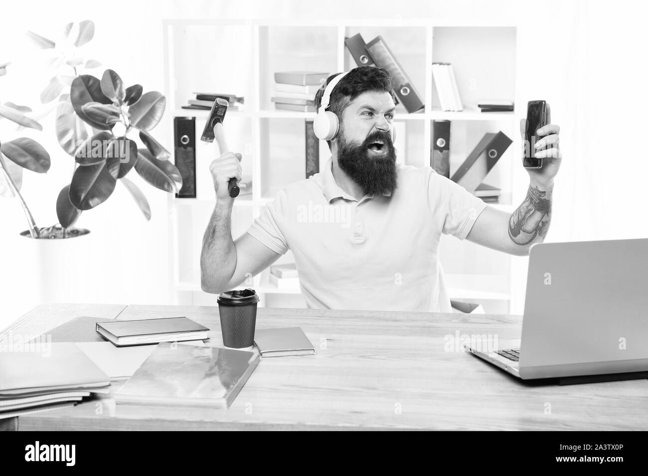 Most annoying thing about work in call center. Incoming call. Annoying client calling. Man bearded guy headphones office swing hammer on smartphone. Spoiled communication. Failed mobile negotiations. Stock Photo