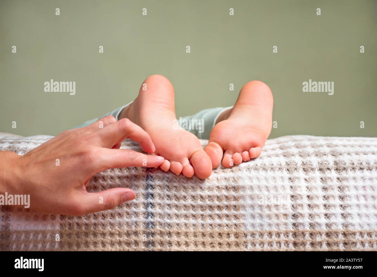 Children's feet. Barefeet on the bed. Kid's feet in bed. Tickling for