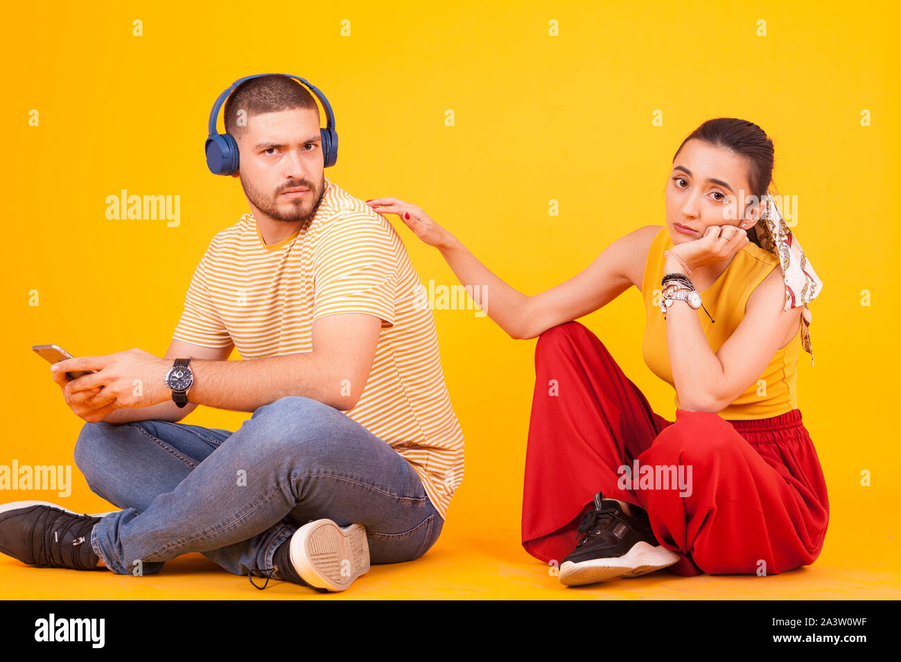 Sad girlfriend on her boyfriend because staying too much on his phone. Relationship problem Stock Photo