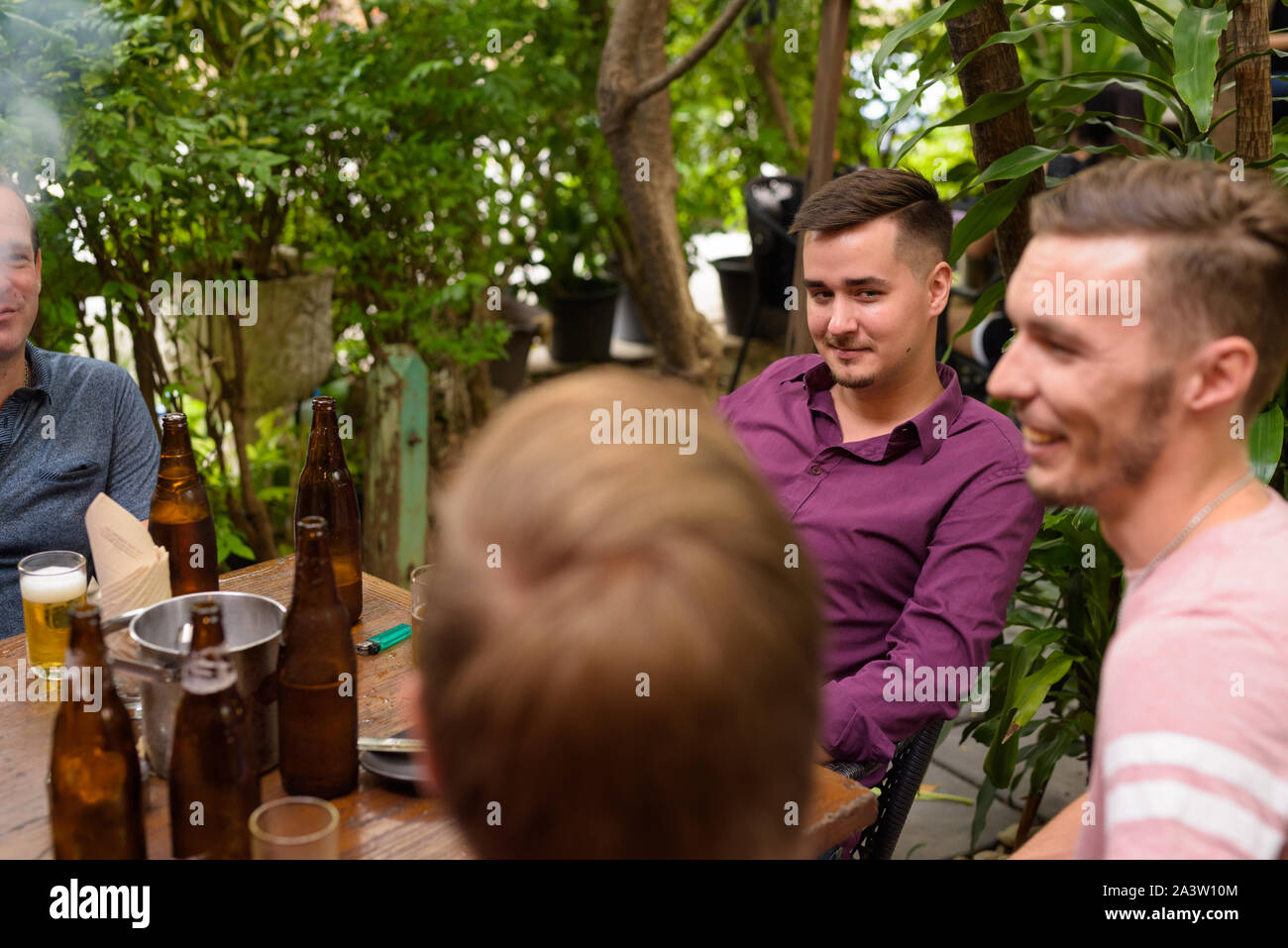 Group of men outdoors sitting and drinking beer Stock Photo