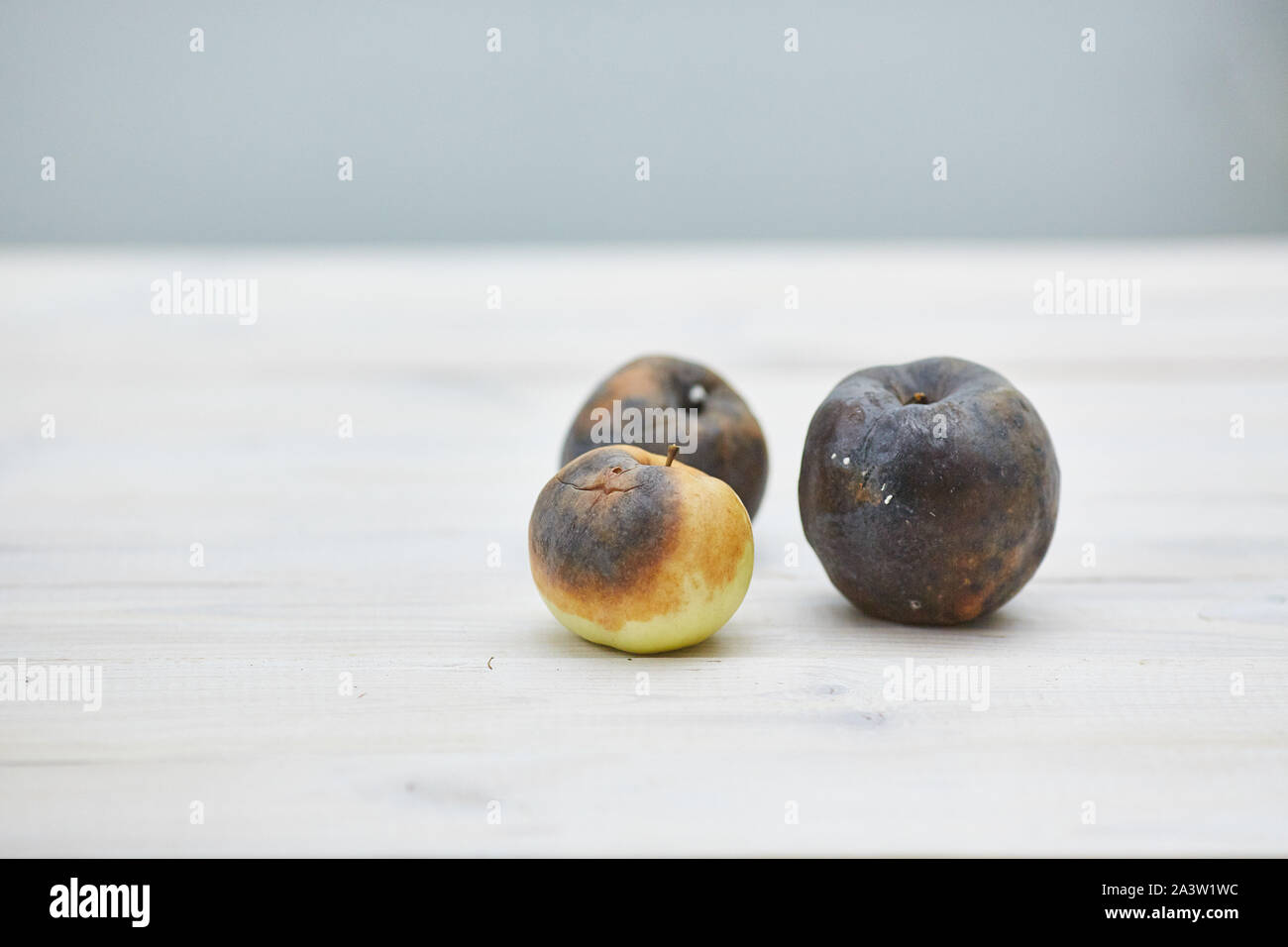 ugly fruit. three rotten apples on the wooden table Stock Photo