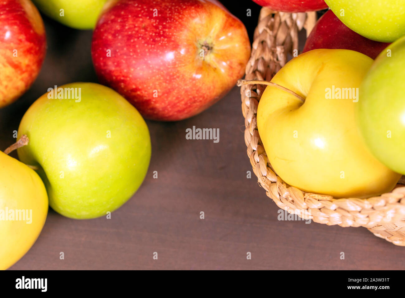 Multicolor apples, apples on bascket, wood background Stock Photo