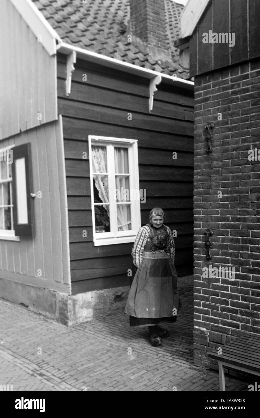 Alte Frau in einer Gasse im Dorf auf der Insel Marken, Niederlande 1971. Old woman in a little lane in the village of Marken island, The Netherlands 1971. Stock Photo