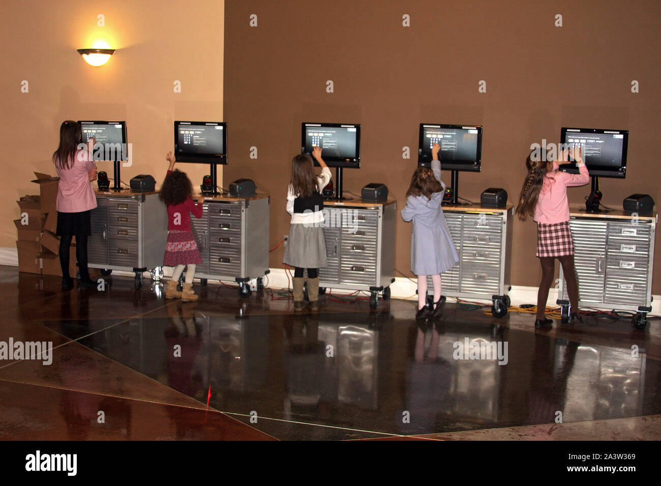 Children using touch-screen interactive monitors to register at Thomas ...