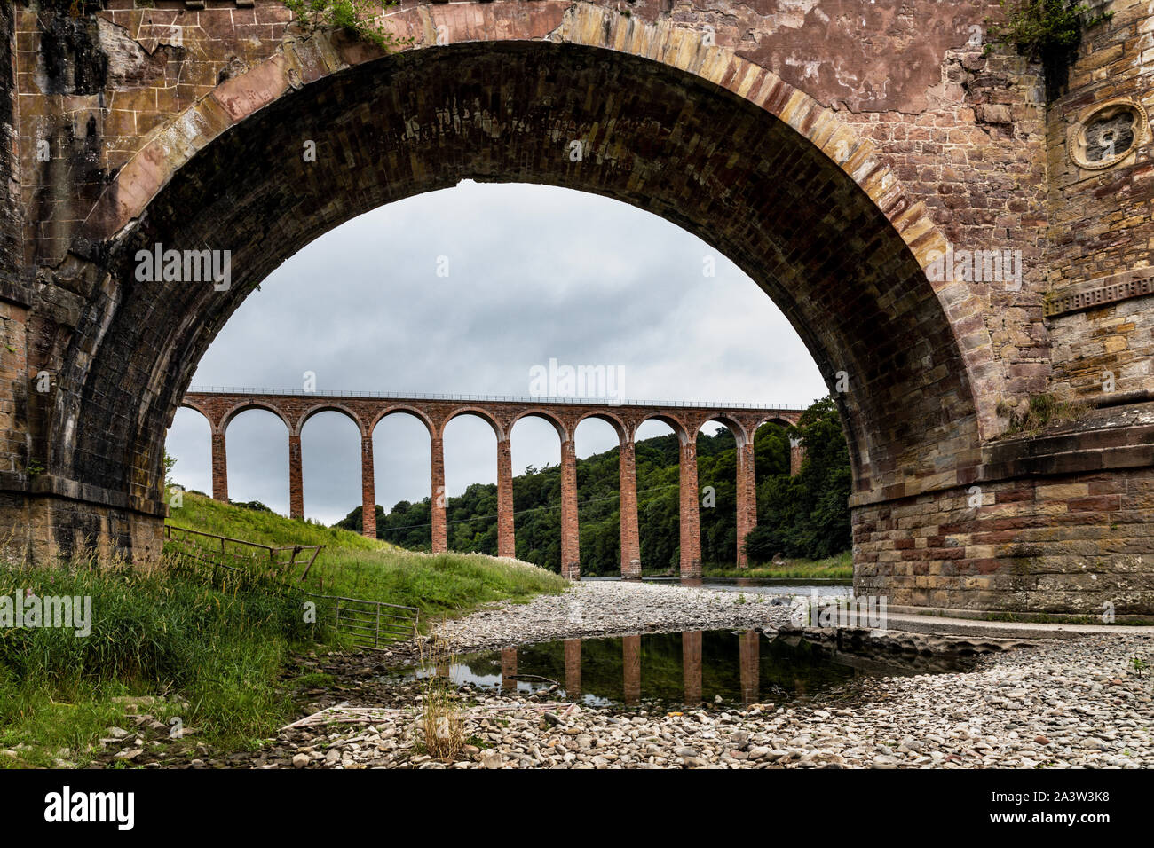 Leaderfoot Viaduct is a disused railway viaduct over the River Tweed, Scottish Borders. It is seen here framed by the nearby old pedestrian bridge. Stock Photo