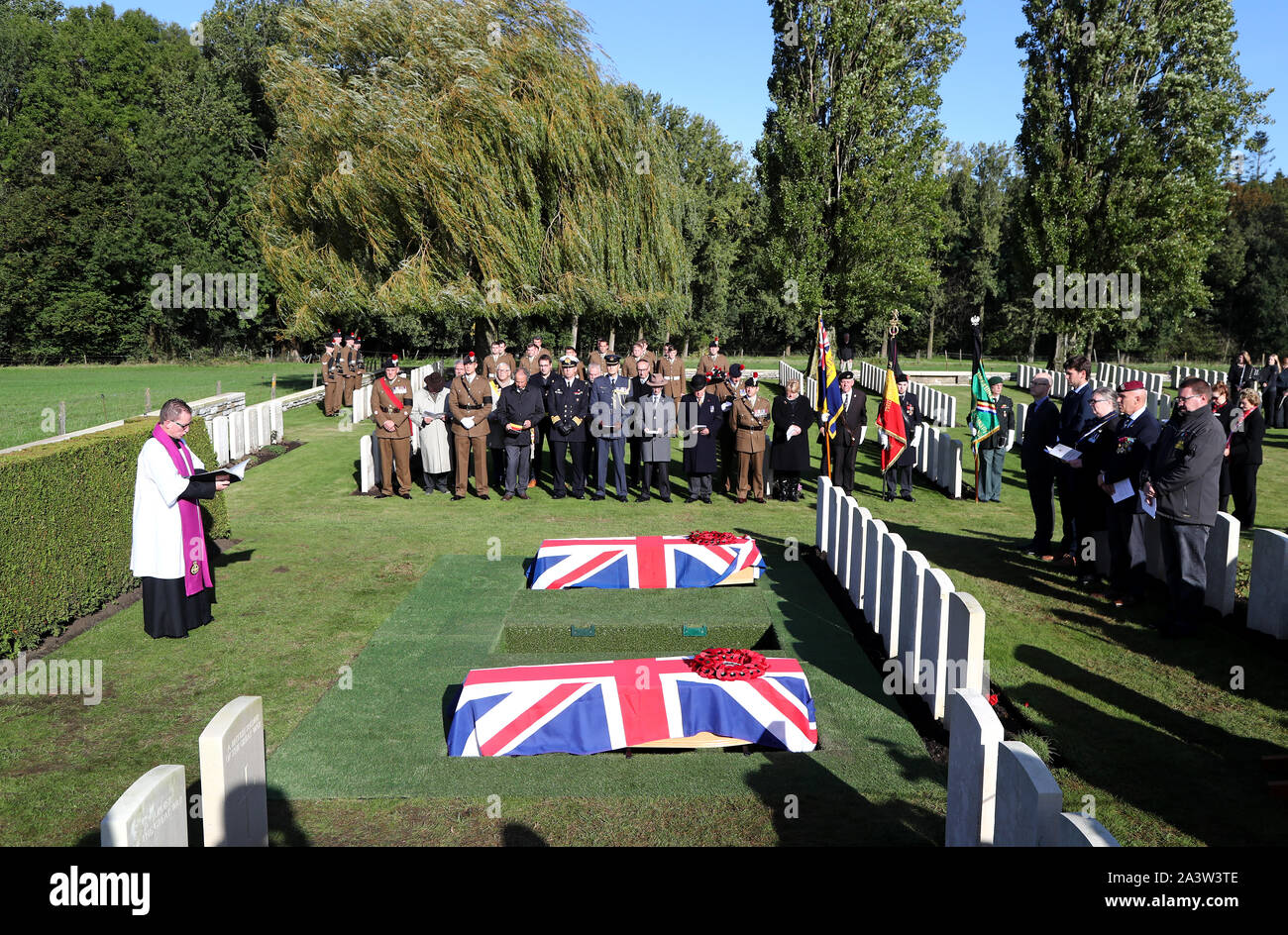 Father Patrick O'Driscoll leads a burial service at the Commonwealth War Graves Commission's Wytschaete Military Cemetery, near Ypres, Belgium, for thirteen unknown soldiers who died fighting in Belgium in the First World War. Stock Photo