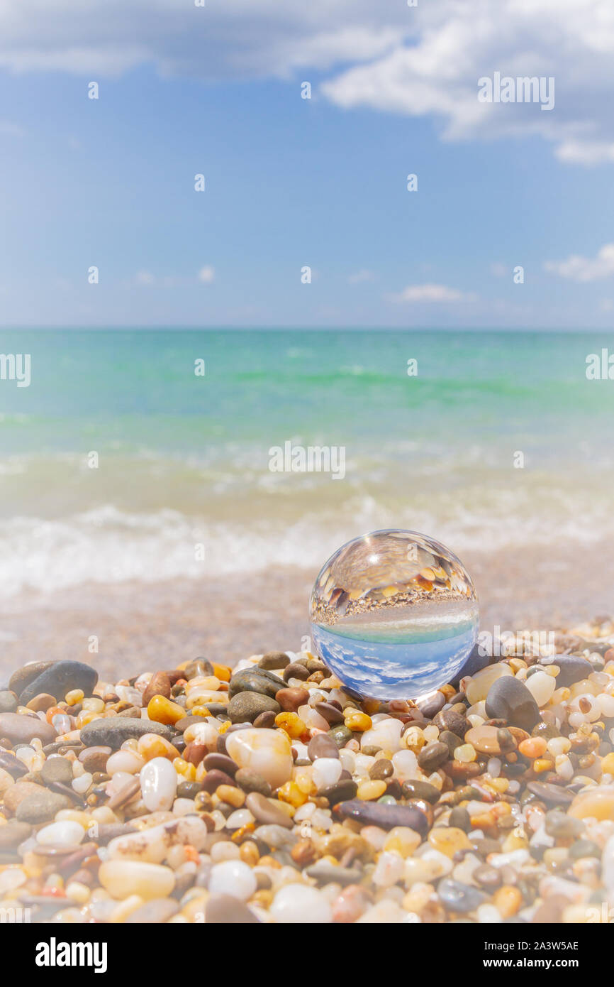 Glass round ball on the beach reflects the sea in summer Stock Photo ...
