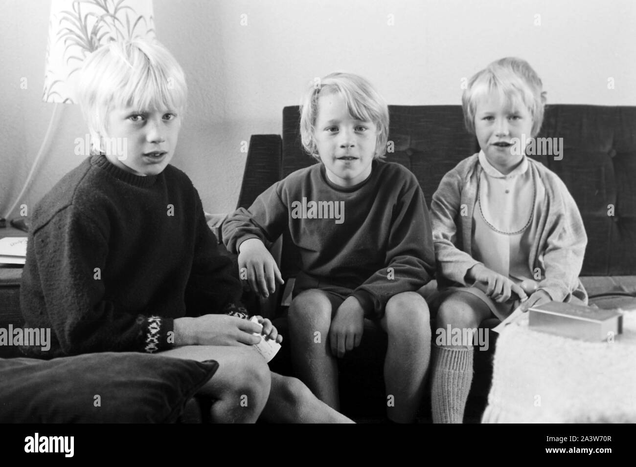 Kinder beschäftigen sich im Wohnzimmer, Deutschland frühe 1970er Jahre. Children at the living room, Germany early 1970s. Stock Photo