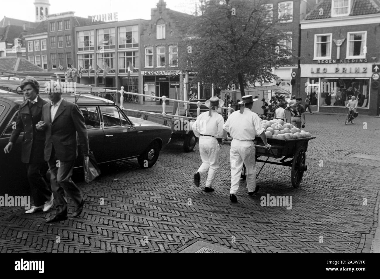 Käseträger fahren Käseballen auf den Käsemarkt in Alkmaar, Niederlande 1971. Cheese carriers put some cheese loaves on their cart to the market at Alkmaar, The Netherlands 1971. Stock Photo